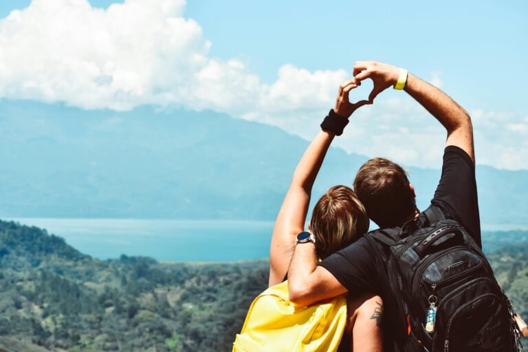 Couple making a heart shape with arms over a beautiful view in Honduras.