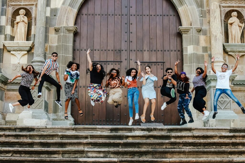 pexels-photo-17664540-17664540 A lively group of friends joyfully jumping on steps outside a historic cathedral.